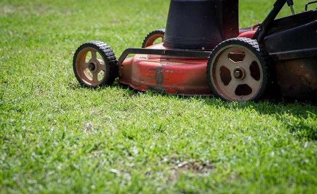 a red lawn mower on a patch of grass